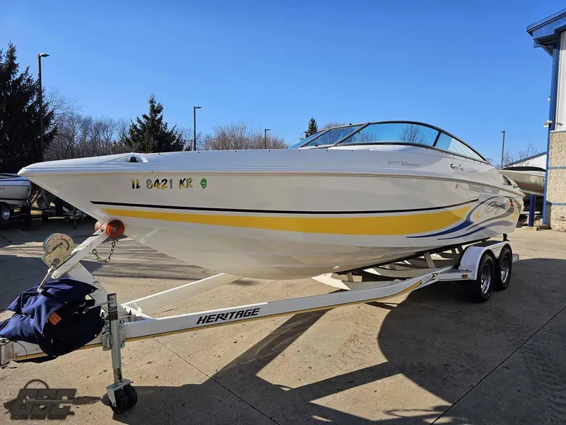 Slide: The Image of 2008 Baja 247 Islander boat on trailer, white with yellow accents, parked outdoors. - 17