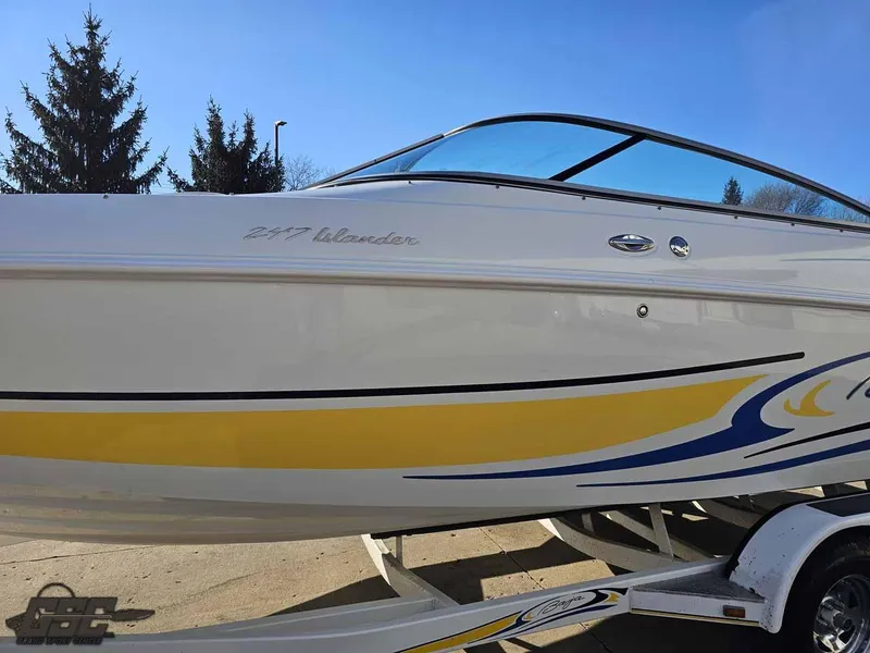 Slide: The Image of 2008 Baja 247 Islander boat with yellow and blue accents on a trailer. - 19