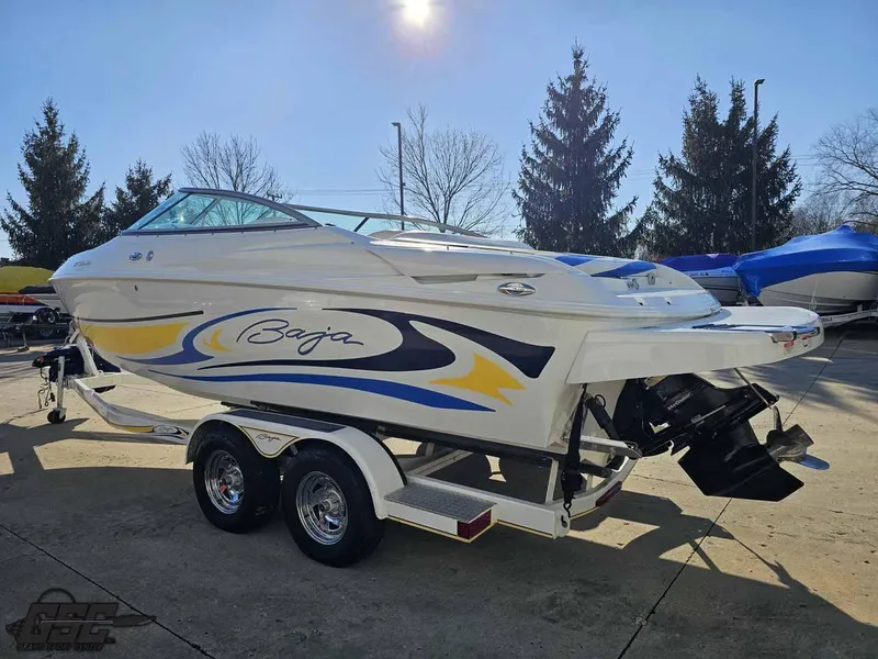Slide: The Image of 2008 Baja 247 Islander boat on trailer, vibrant graphics, parked outdoors. - 24