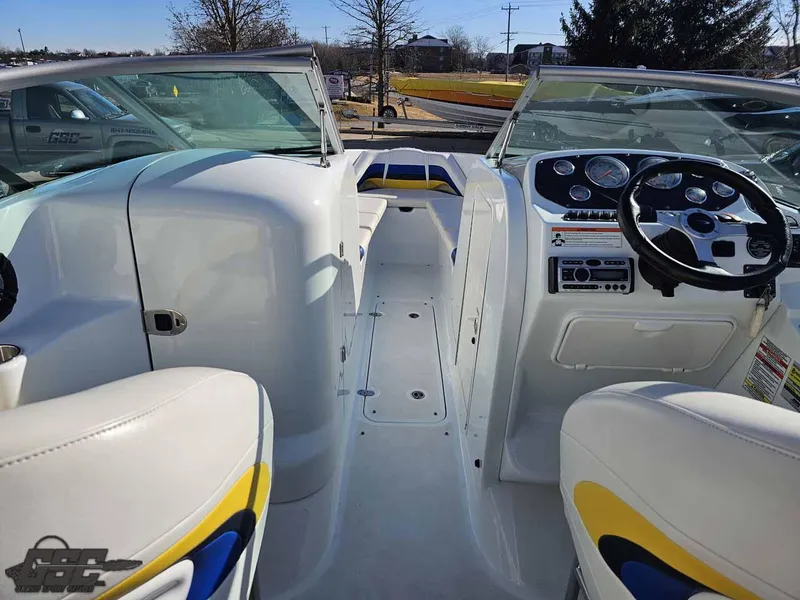 Slide: The Image of 2008 Baja 247 Islander boat interior with white and yellow seating, dashboard, and steering wheel. - 49