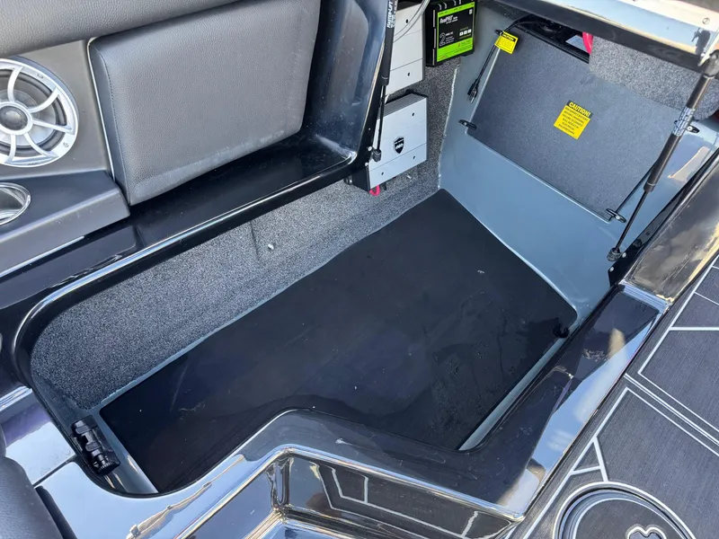 Slide: The Image of 2025 ATX Surf Boats 22 Type-S storage compartment with speaker and safety labels. - 8