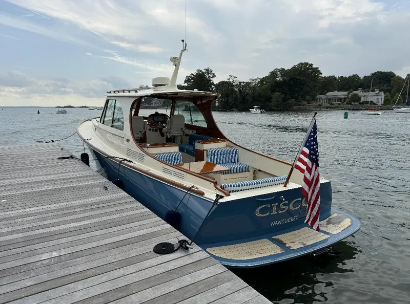 Slide: The Image of 2018 Hinckley Picnic Boat 37 MKIII docked by the water, displaying an American flag. - 8