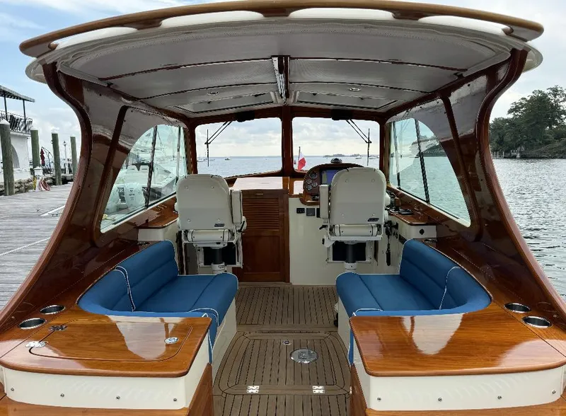 Slide: The Image of 2018 Hinckley Picnic Boat 37 MKIII interior with blue seating and wooden finishes. - 12