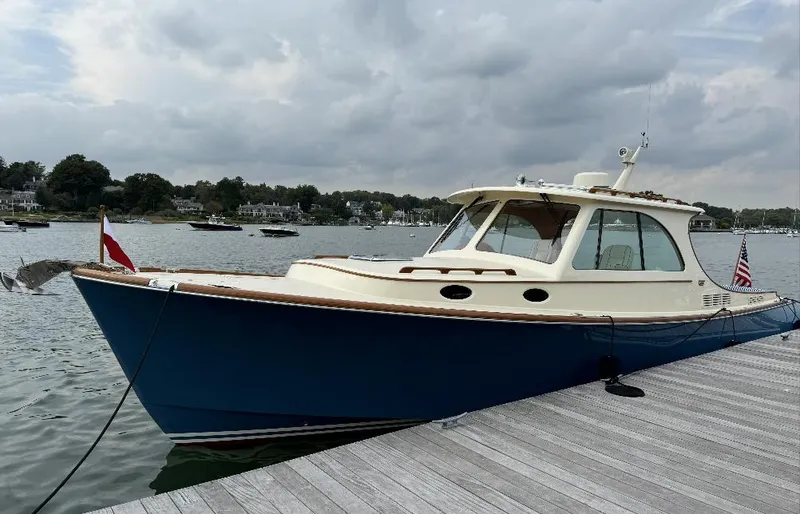 Slide: The Image of 2018 Hinckley Picnic Boat 37 MKIII docked on a calm lake under cloudy skies. - 4