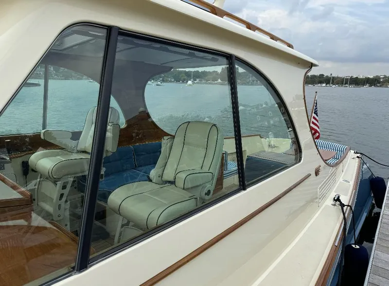 Slide: The Image of 2018 Hinckley Picnic Boat 37 MKIII docked, showcasing elegant interior and American flag. - 6