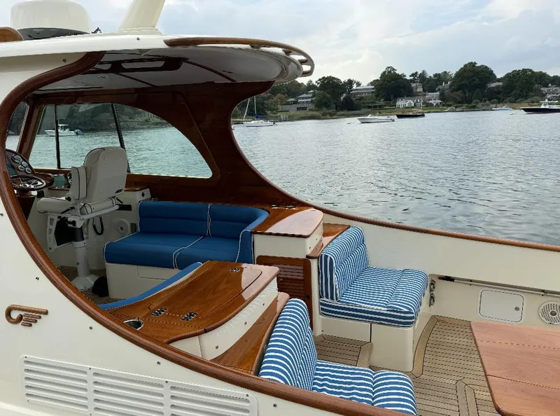 Slide: The Image of 2018 Hinckley Picnic Boat 37 MKIII with elegant seating, docked by a scenic waterfront. - 9