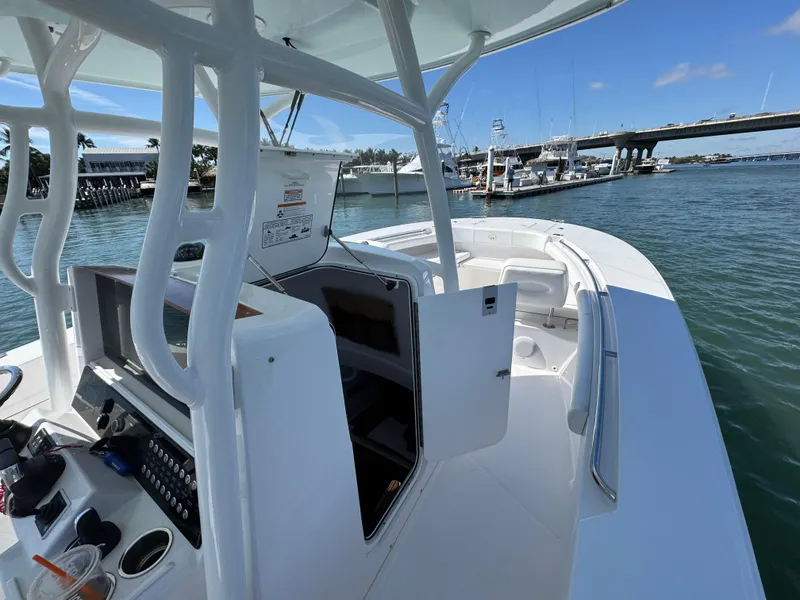 Slide: The Image of 2024 Southport 30 FE boat docked, featuring open helm and spacious deck. - 11