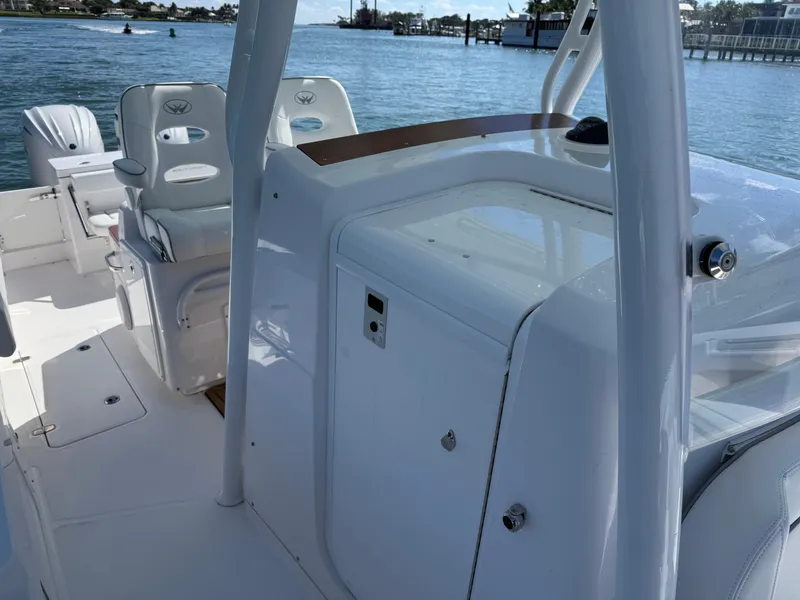 Slide: The Image of 2024 Southport 30 FE boat interior with seating and console, docked by the water. - 12