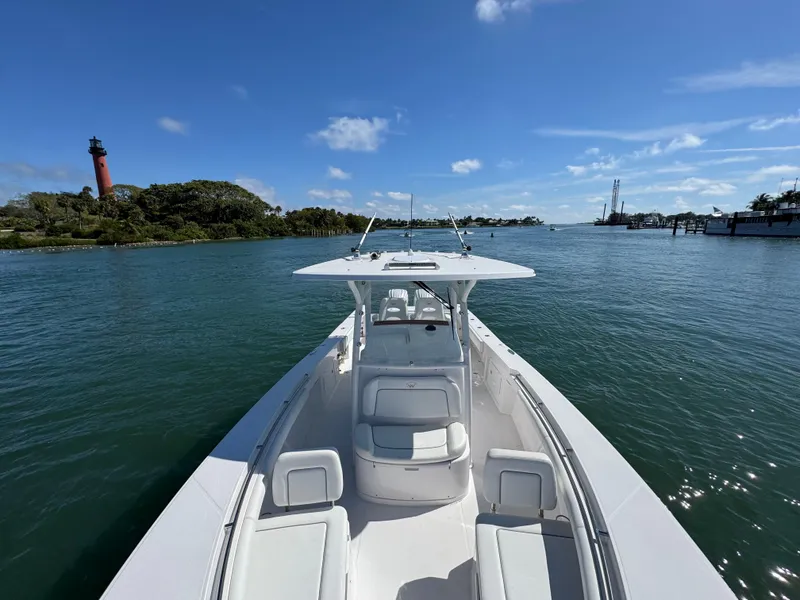 Slide: The Image of 2024 Southport 30 FE boat on calm water with lighthouse in background. - 13