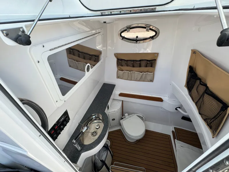 Slide: The Image of 2024 Southport 30 FE boat interior with sink, toilet, and storage compartments. - 23