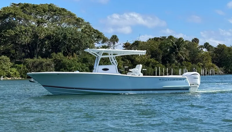 Slide: The Image of 2024 Southport 30 FE boat cruising on a scenic waterway with lush greenery. - 3