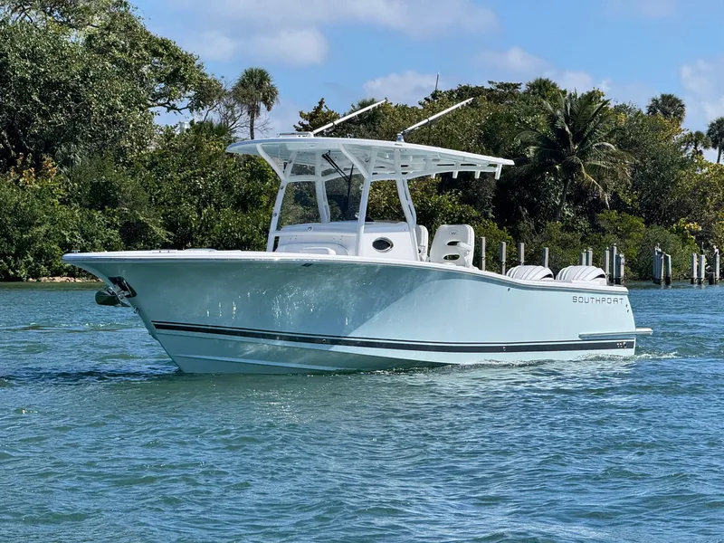 Slide: The Image of 2024 Southport 30 FE boat cruising on a sunny day near lush greenery. - 4