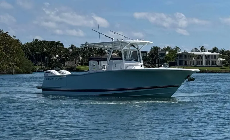 Slide: The Image of 2024 Southport 30 FE boat cruising on a sunny day near waterfront homes. - 7