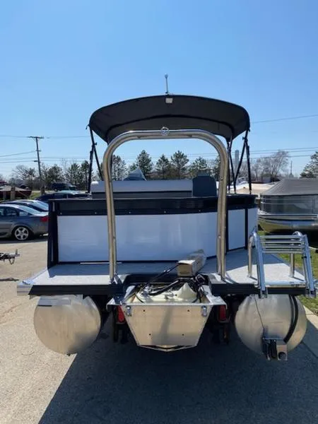 Slide: The Image of 2023 Qwest 824 E-Class Splash Pad Rw LTZ pontoon boat, rear view, parked outdoors. - 2