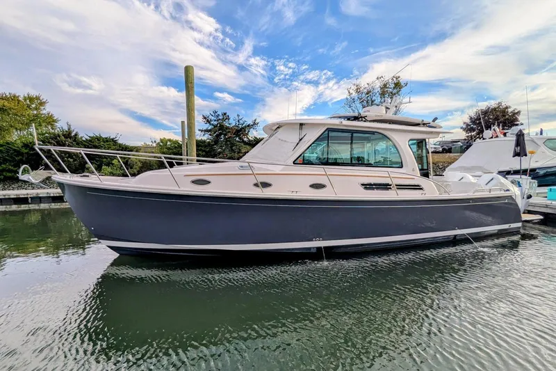 The Image of 2024 Back Cove 39O cruising on a calm lake with forested shoreline in the background. - 0