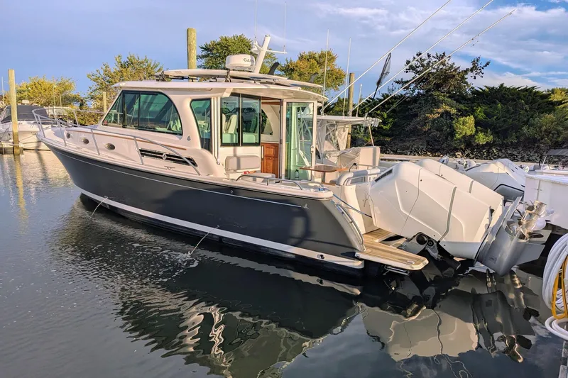 Slide: The Image of 2024 Back Cove 39O boat docked on calm water under a partly cloudy sky. - 1