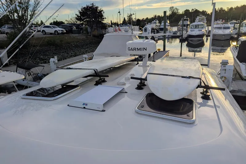 Slide: The Image of 2024 Back Cove 39O boat with surfboards and Garmin equipment at a marina. - 12
