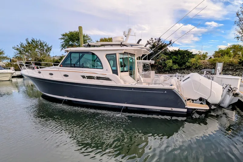 Slide: The Image of 2024 Back Cove 39O boat docked in serene marina setting. - 2