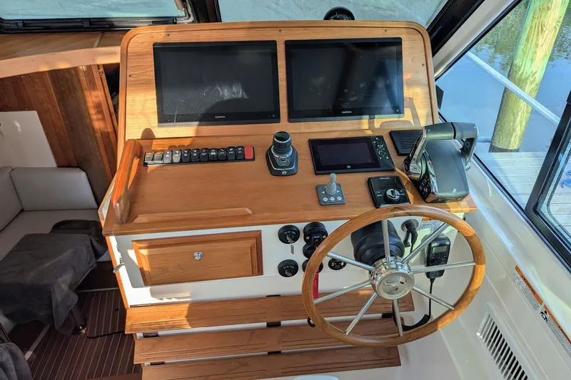 Slide: The Image of 2024 Back Cove 39O helm with dual screens, wooden wheel, and modern controls. - 22