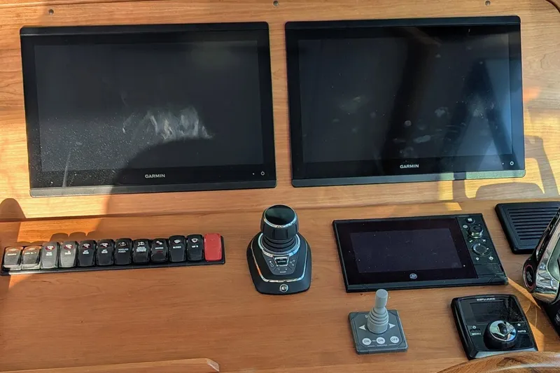 Slide: The Image of Control panel of 2024 Back Cove 39O boat with Garmin displays and navigation controls. - 23