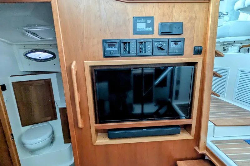Slide: The Image of 2024 Back Cove 39O interior with TV, control panel, and bathroom view. - 37