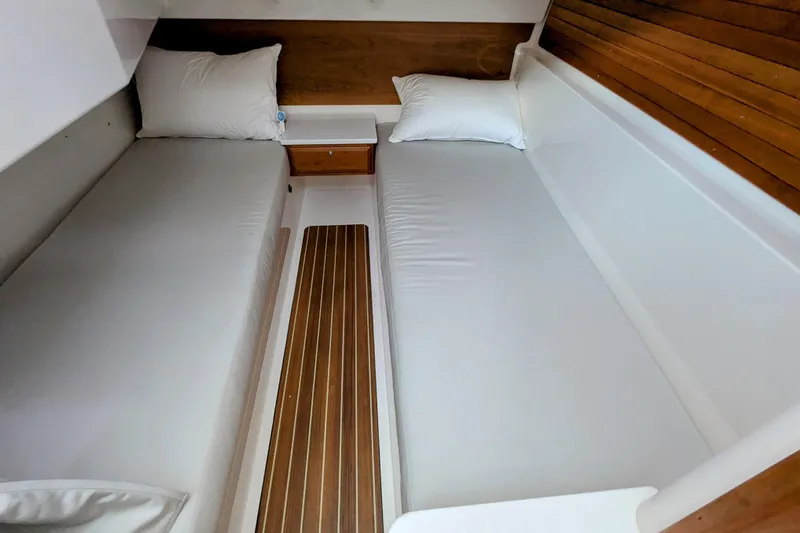 Slide: The Image of 2024 Back Cove 39O cabin interior with twin beds and wooden accents. - 39