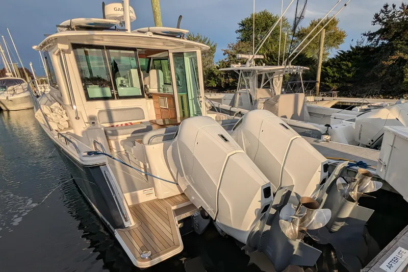 Slide: The Image of 2024 Back Cove 39O boat docked, featuring dual outboard engines and modern design. - 5