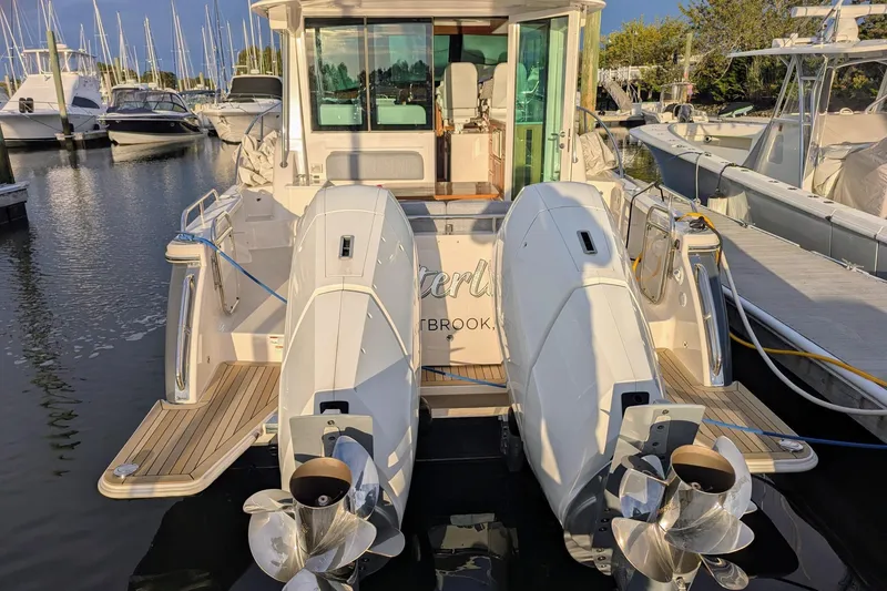 Slide: The Image of 2024 Back Cove 39O boat docked with dual outboard engines, marina background. - 6