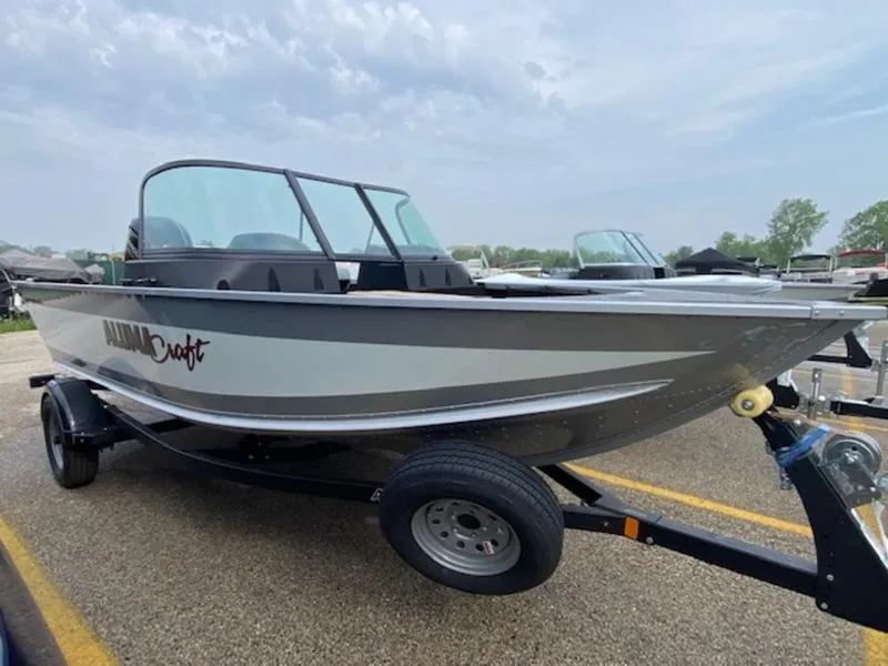Slide: The Image of 2022 Alumacraft Competitor 165 Sport boat on trailer, parked outdoors. - 0