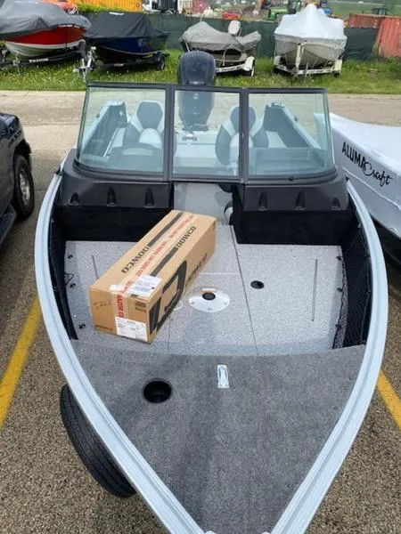 Slide: The Image of 2022 Alumacraft Competitor 165 Sport boat with a cardboard box on deck. - 2