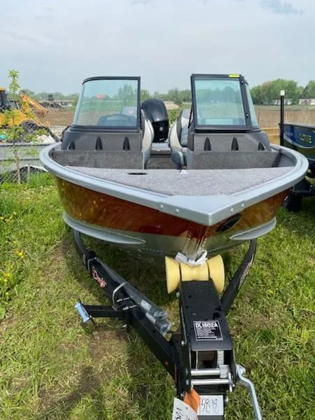 Slide: The Image of 2022 Alumacraft Voyageur 175 Sport boat on trailer, parked on grass. - 2