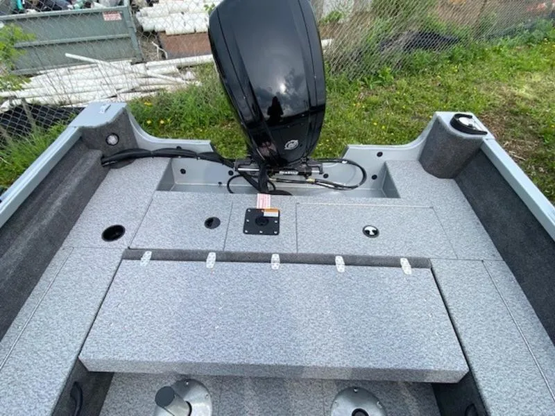 Slide: The Image of 2022 Alumacraft Voyageur 175 Sport boat interior with motor, gray seating, and storage compartments. - 3