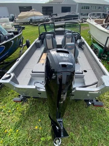 Slide: The Image of 2022 Alumacraft Voyageur 175 Sport boat with 90 HP engine, parked on grass. - 7