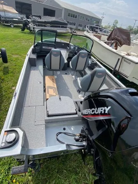Slide: The Image of 2022 Alumacraft Voyageur 175 Sport boat with Mercury engine, parked on grass. - 8