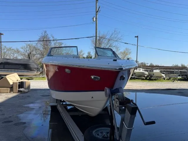 Slide: The Image of 2018 Cobalt R3 boat with red and white hull on a trailer in a marina. - 10