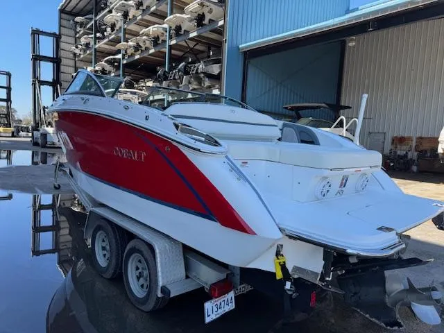 Slide: The Image of 2018 Cobalt R3 boat on trailer, red and white, parked near storage facility. - 5