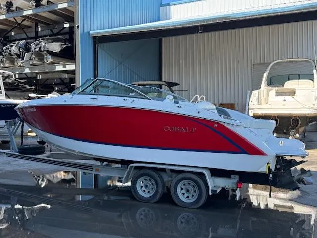 Slide: The Image of 2018 Cobalt R3 boat in red and white on a trailer at a marina. - 6