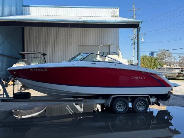 Slide: The Image of 2018 Cobalt R3 boat on trailer, red and white, parked outside a building. - 7