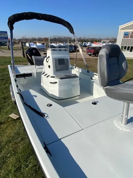 Slide: The Image of 2023 Lowe Bay20 boat with seating and canopy, displayed outdoors on grass. - 13