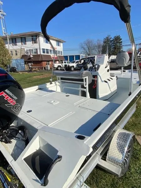 Slide: The Image of 2023 Lowe Bay20 boat with canopy, spacious deck, and powerful outboard motor. - 14