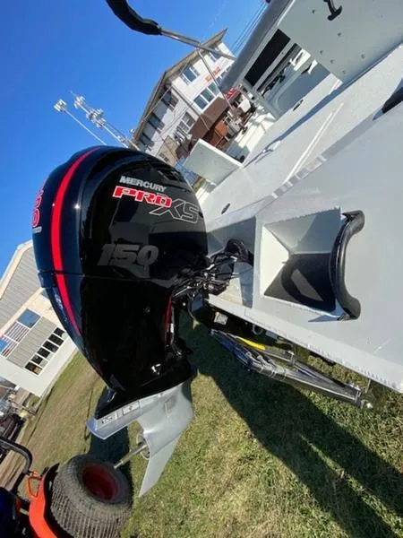 Slide: The Image of 2023 Lowe Bay20 boat with Mercury Pro XS 150 engine, parked outdoors. - 17