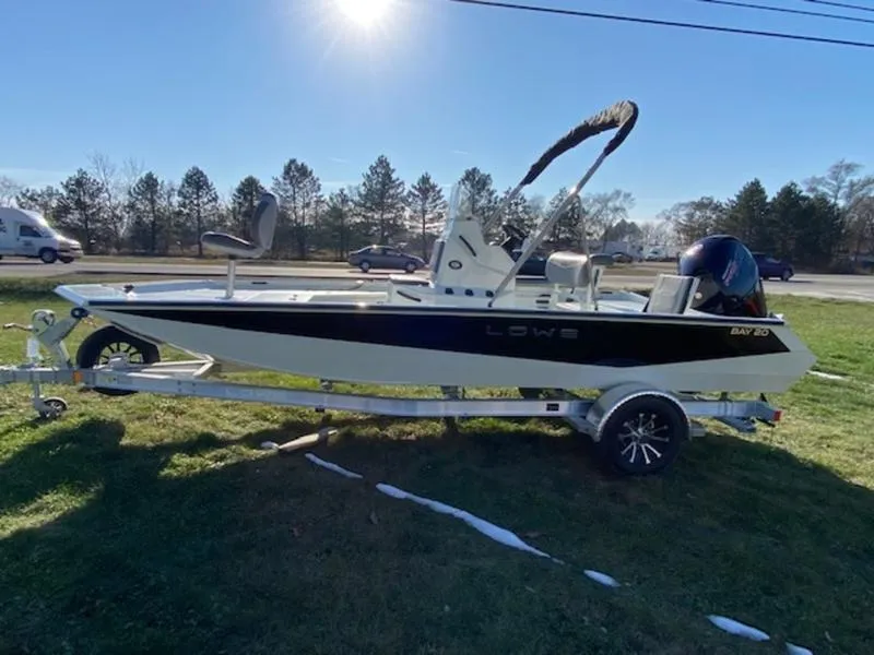 Slide: The Image of 2023 Lowe Bay20 boat on trailer, parked on grass under sunny sky. - 6