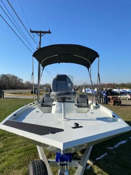 Slide: The Image of 2023 Lowe Bay20 boat with canopy on trailer, parked on grass under clear blue sky. - 8