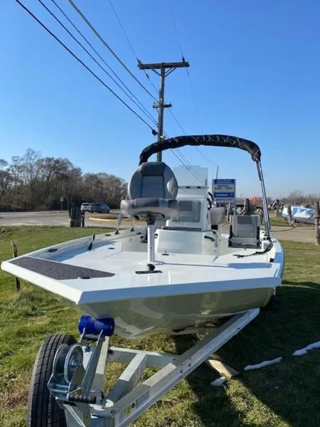 Slide: The Image of 2023 Lowe Bay20 boat on trailer, parked on grass under clear blue sky. - 9