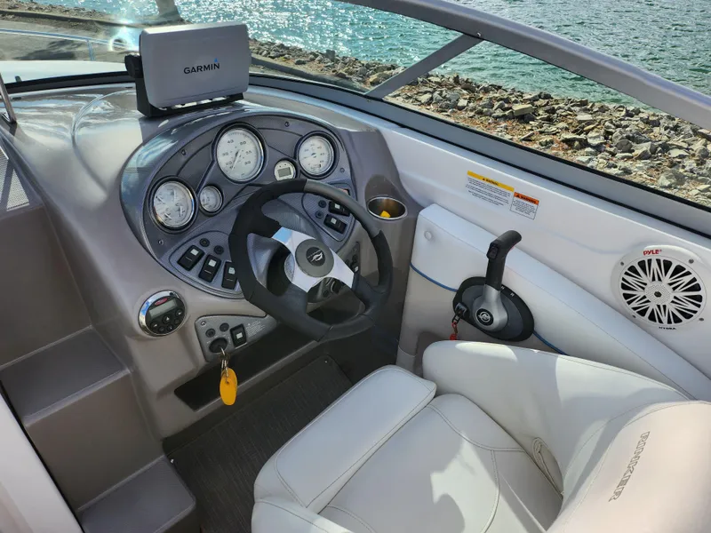 Slide: The Image of 2007 Rinker 246 Captiva Cuddy boat cockpit with steering wheel and Garmin navigation system. - 12