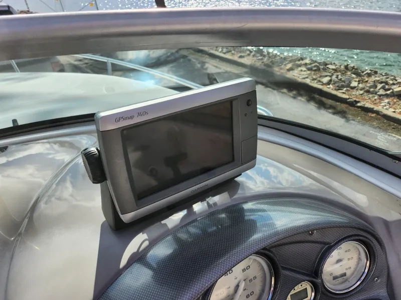 Slide: The Image of GPS device on 2007 Rinker 246 Captiva Cuddy boat dashboard by the water. - 13