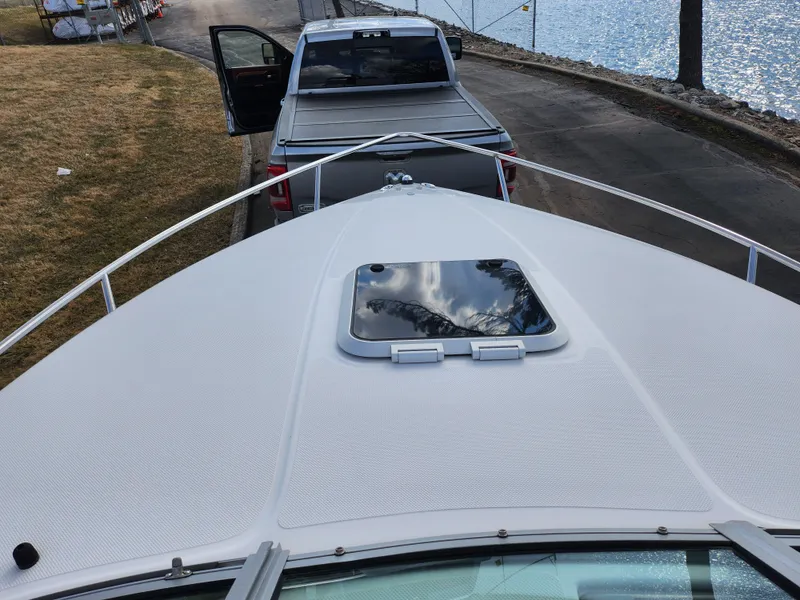 Slide: The Image of 2007 Rinker 246 Captiva Cuddy boat on trailer near a lake. - 14