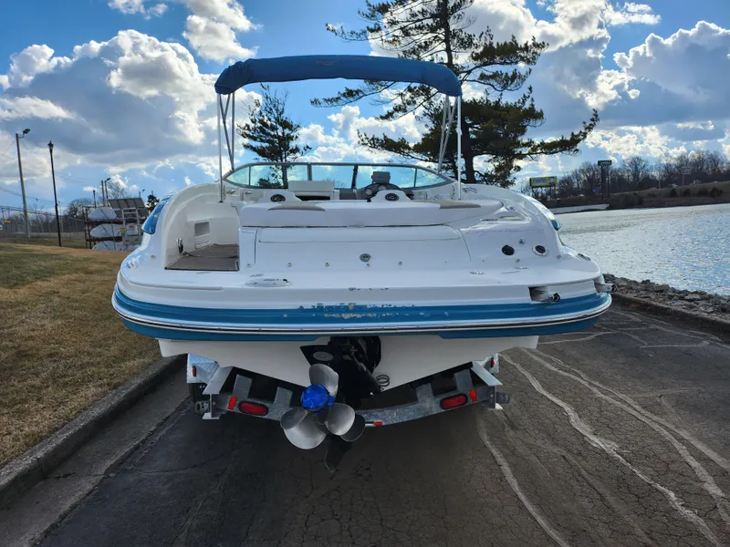 Slide: The Image of 2007 Rinker 246 Captiva Cuddy boat on trailer by a lake under a cloudy sky. - 2