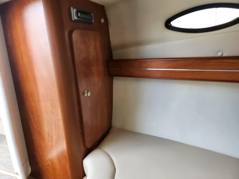 Slide: The Image of 2007 Rinker 246 Captiva Cuddy cabin interior with wood paneling and seating. - 24