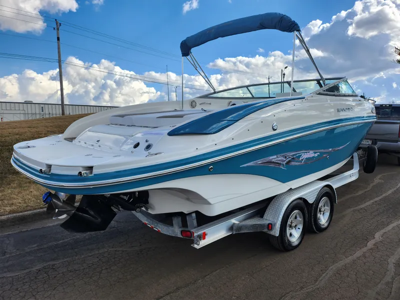 Slide: The Image of 2007 Rinker 246 Captiva Cuddy boat on trailer, blue and white design, parked outdoors. - 3